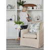Owen Chair styled with a blue pillow and gold accent table against white shelving. Styled view.