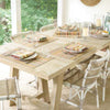 Pebble Natural Indoor/Outdoor Rug styled under a neutral dining table. Styled view.
