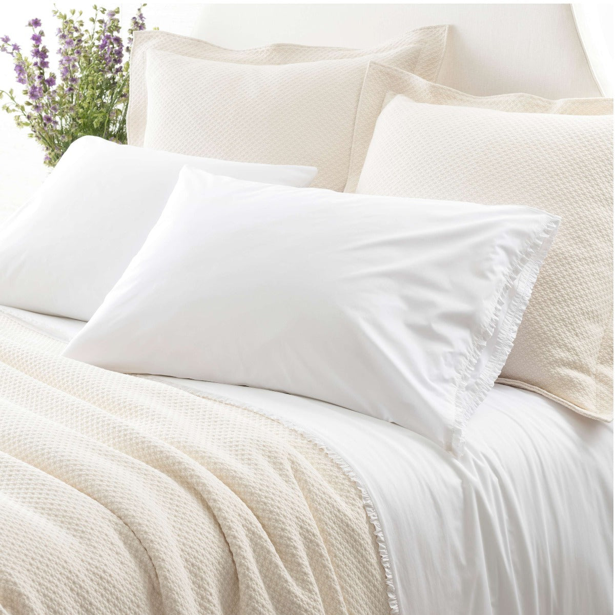 Petite Ruffle White sheet set styled with neutral bedding. Styled view. 