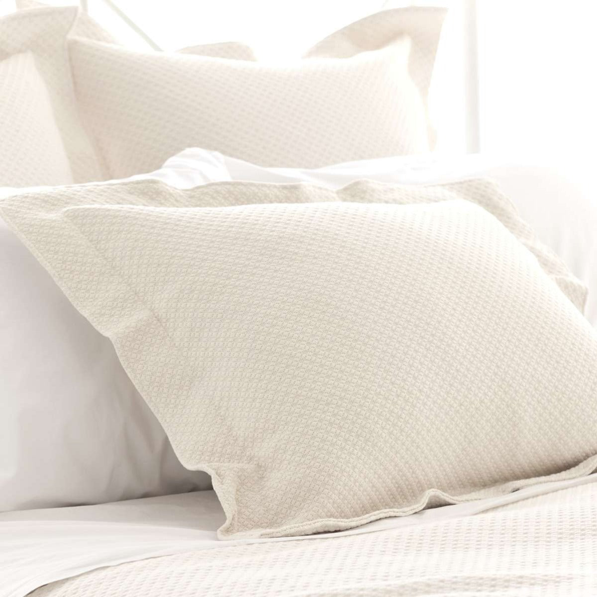 Petite Trellis Ivory Matelasse sham styled with neutral bedding. Styled view.