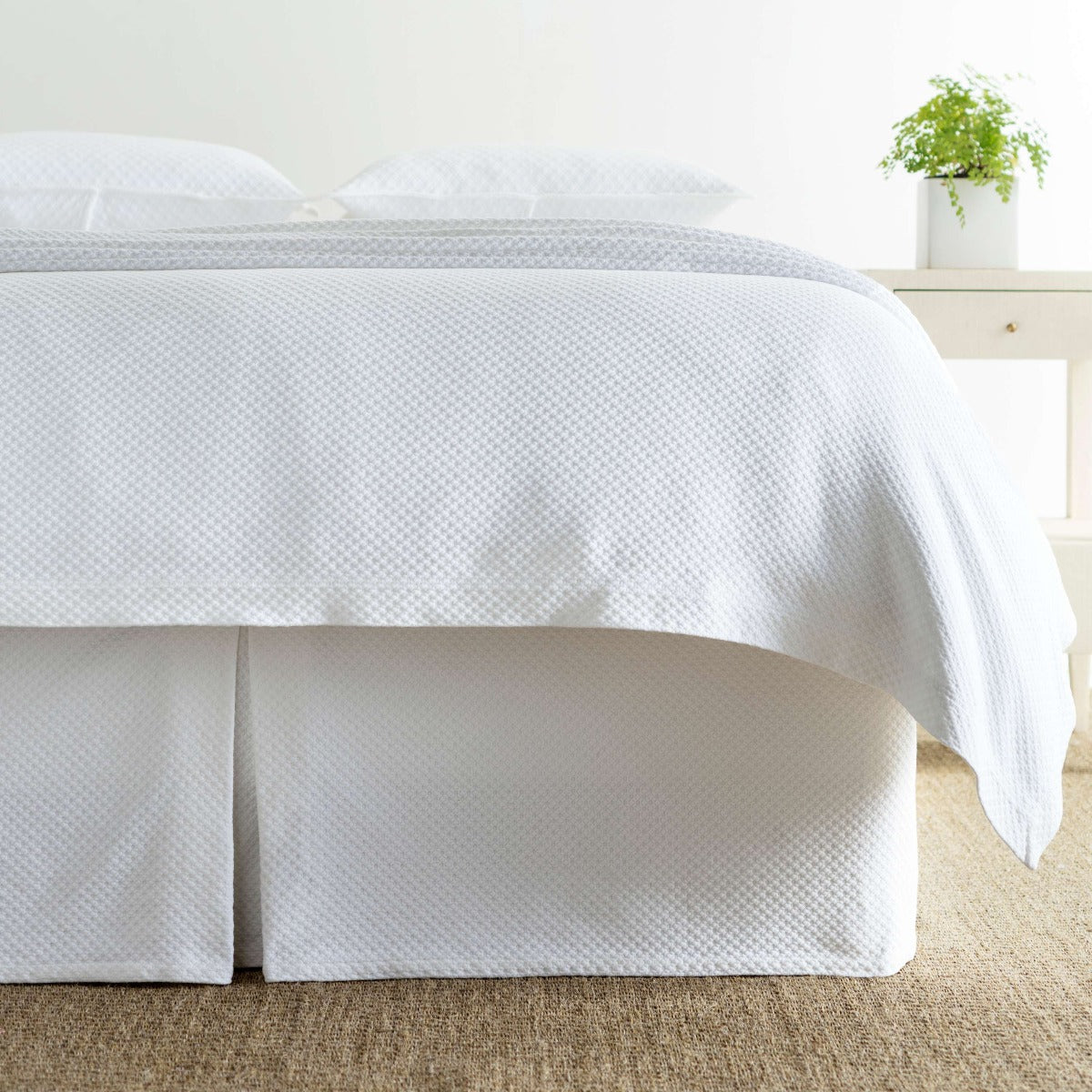 Petite Trellis White Matelasse bed skirt styled with white bedding. Styled view.