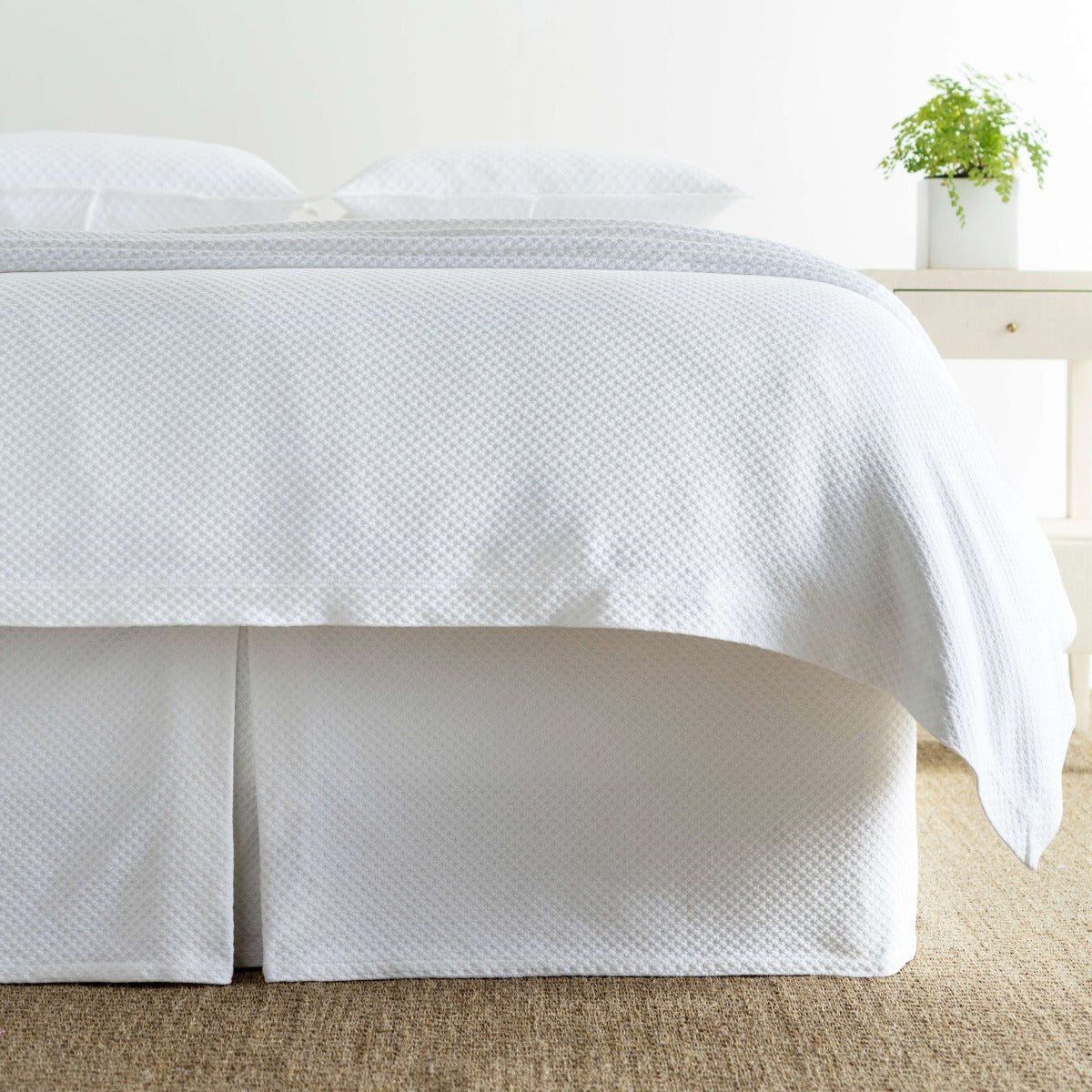 Petite Trellis White Matelasse bed skirt styled with white bedding. Styled view. 
