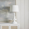 Piper Table Lamp styled on a white cabinet with artwork. Styled view.