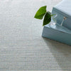 Pixel Sky Woven Sisal/Wool Rug styled under blue boxes. Styled view.