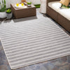 Portland Outdoor Rug - Charcoal styled with brown outdoor patio furniture. Styled view.