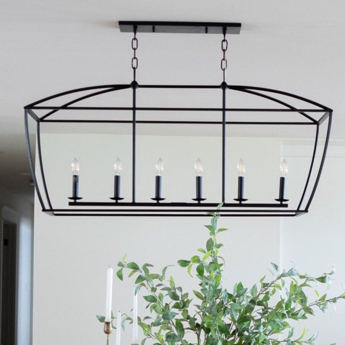 Quinn Chandelier - Black Iron styled in a white dining room with greenery. Styled view.
