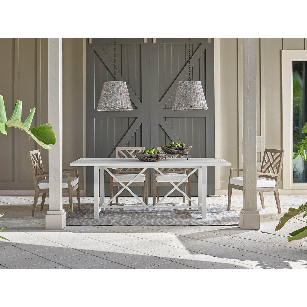 Augustine Outdoor Pendant - Large styled above an outdoor dining table with bar doors. Styled view.