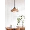 Surfside Wood Pendant styled over a wood table with books and greenery. Styled view.