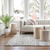 Rosalie Round Stump styled beside a grey sofa and rug in a neutral living room. Styled view.