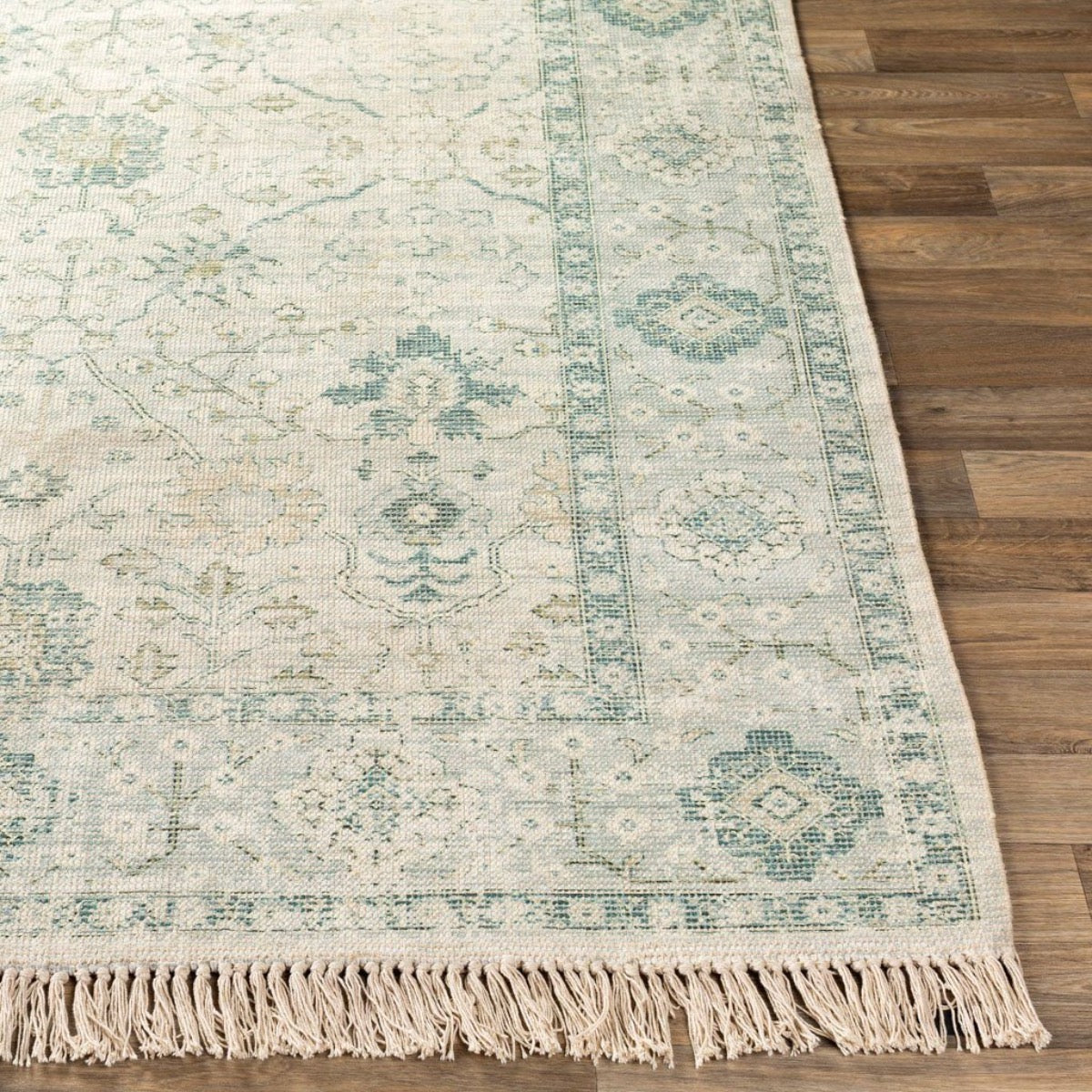 Sage Rug on light wood floor. Styled view.