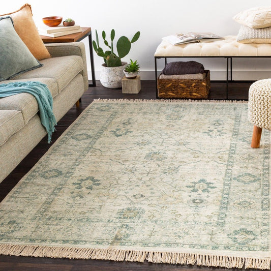 Sage Rug styled with a grey sofa and stool. Styled view.