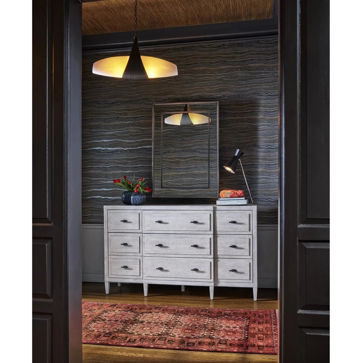 Sam Dresser styled with greenery, books and table lamp in a dark room. Styled view.