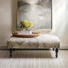 Samson Grey Indoor/Outdoor Rug styled under a grey ottoman in a hallway. Styled view.