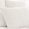 Seychelles Dove White Quilted Sham styled with white sheets. Styled view.