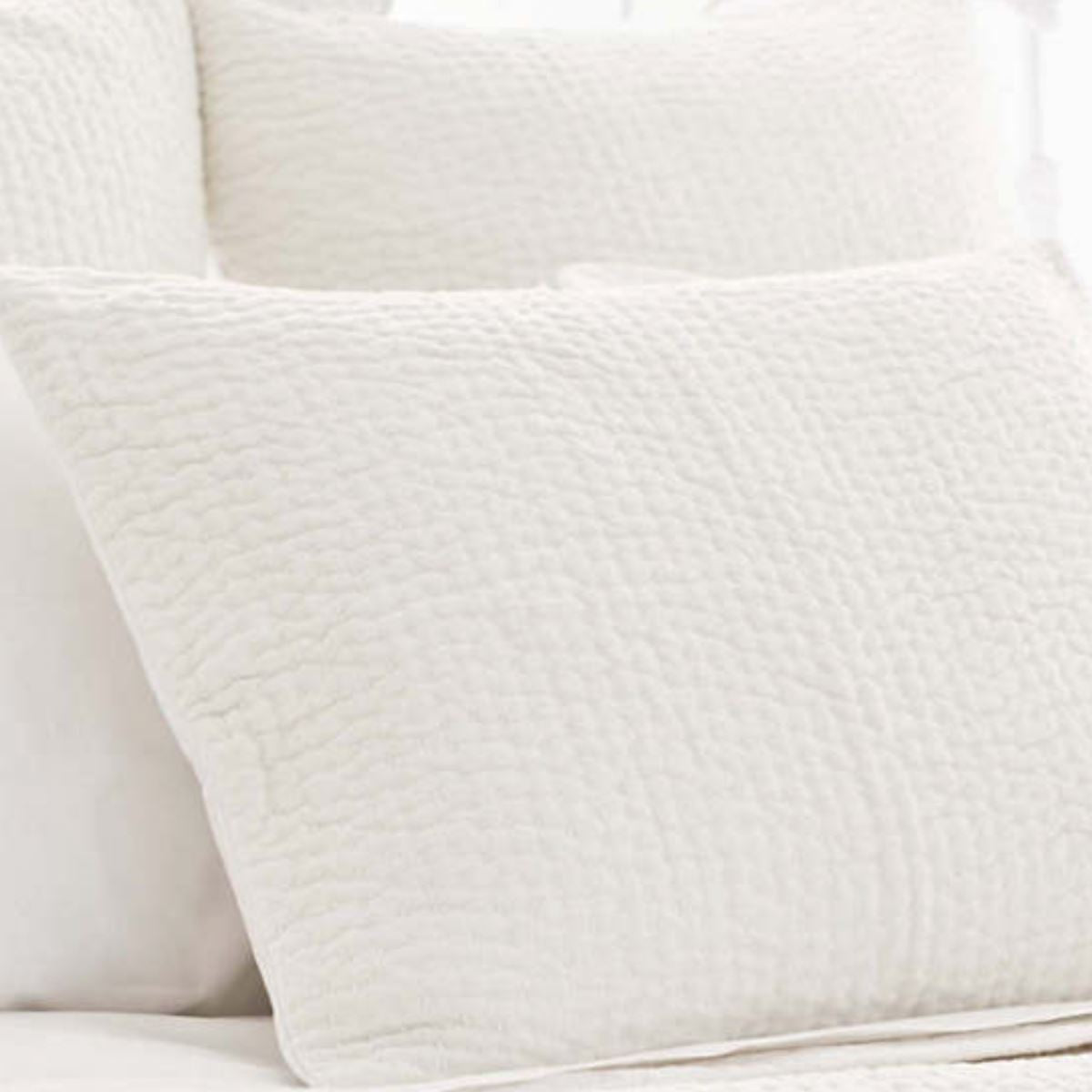 Seychelles Dove White Quilted Sham styled with white sheets. Styled view.