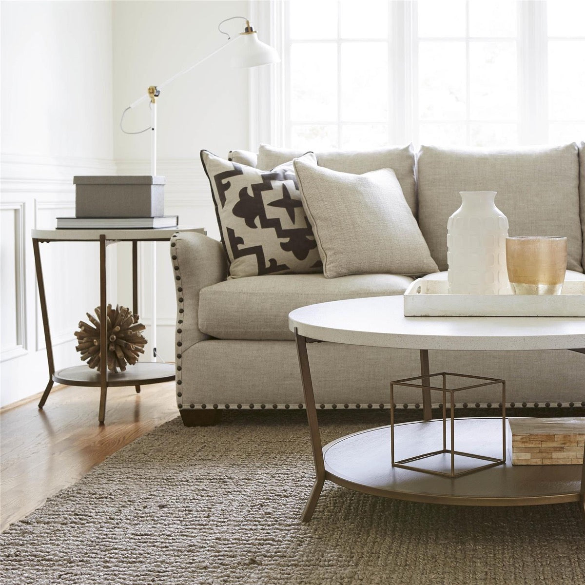 Tilley End Table styled with decorative gold ball, storage boxes and book beside a grey sofa. Styled view.