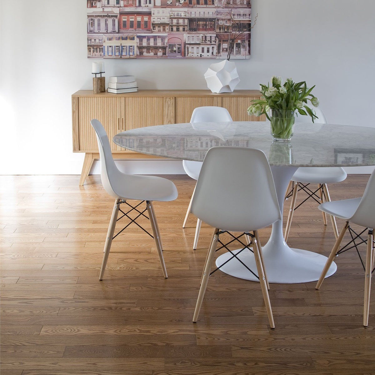 Trumpet Dining Table Oval with Marble Top - Large styled with white chairs and florals. Styled view.