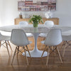 Trumpet Dining Table Oval with Marble Top - Large styled with white chairs and wood console table on light wood floors. Styled view.
