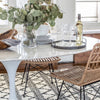 Trumpet Dining Table Oval with Marble Top - Large styled with wicker chairs, serveware and greenery. Styled view.