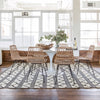Trumpet Dining Table Oval with Marble Top - Small styled on a black and white rug with wicker chairs. Styled view.