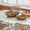 Trumpet Dining Table Oval with Marble Top - Small styled with wood bowls and wicker chairs. Styled view.