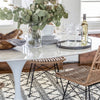 Trumpet Dining Table Oval with Marble Top - Small styled with wicker chairs, serveware and greenery centrepiece. Styled view.