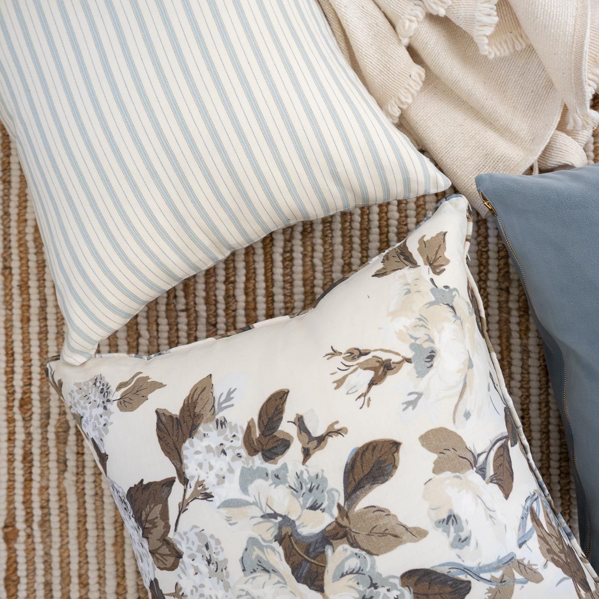 Twiggy Natural Woven Wool/Jute Rug styled with accent pillows. Styled view.