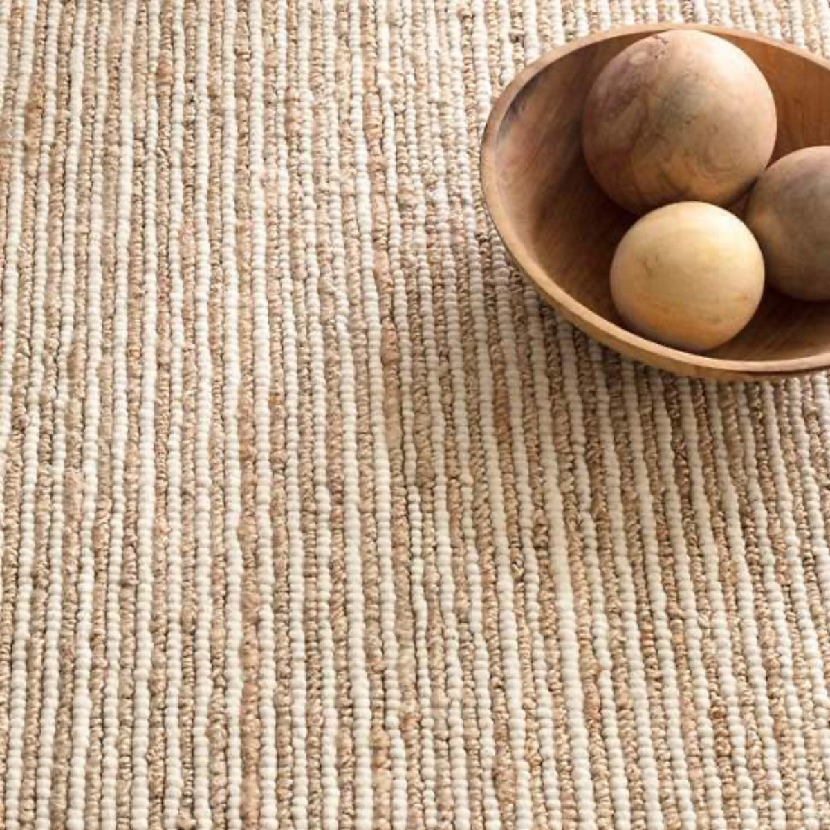 Twiggy Natural Woven Wool/Jute Rug styled under wooden decor. Styled view.