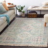 Victoria Rug styled with a grey sofa, greenery and neutral seating. Styled view.