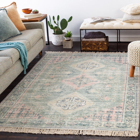 Victoria Rug styled with a grey sofa, greenery and neutral seating. Styled view.