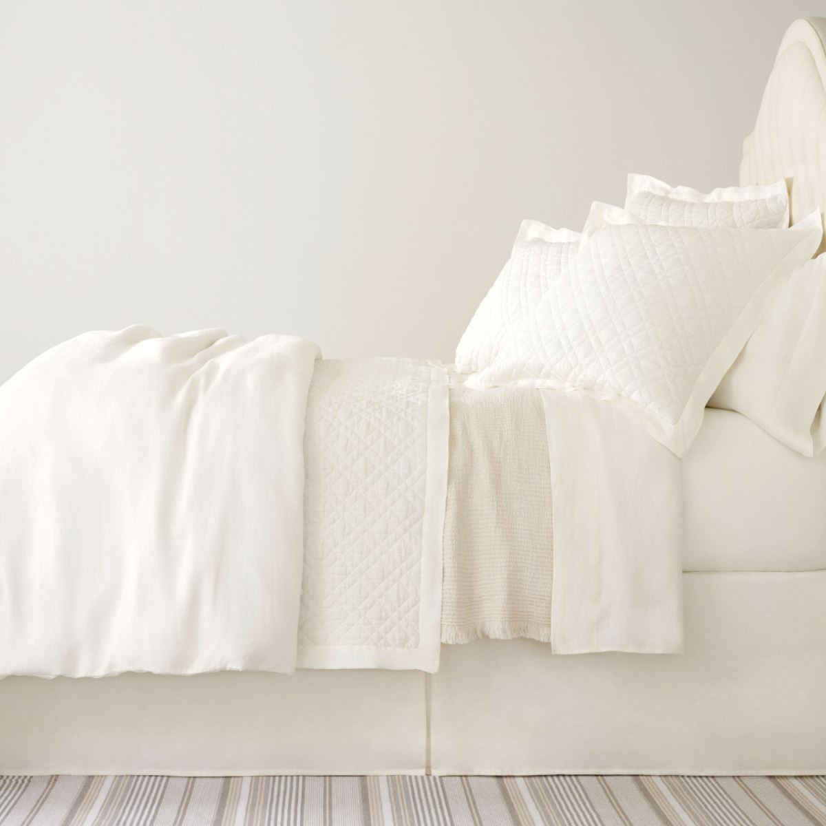 Washed Linen Ivory Quilt styled with white sheets. Styled view.