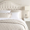 Washed Linen Natural Quilt styled with white sheets. Styled view.
