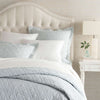 Washed Linen Sky Quilt styled with white sheets. Styled view.