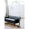Brighton Floor Lamp stayed beside a green leather sofa. Styled view.