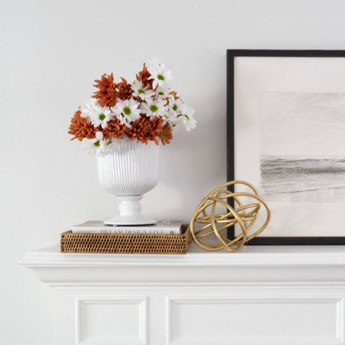 Wilmot Rattan Tray styled with florals and decor on a white mantel. Styled view.