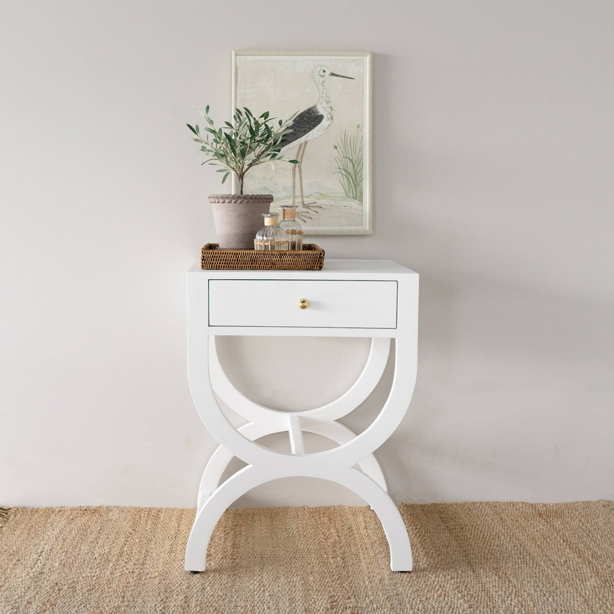 Wilmot Rattan Tray styled on a white accent table. Styled view.