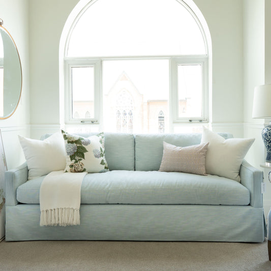 Light blue sofa with decorative pillows in a bright living room