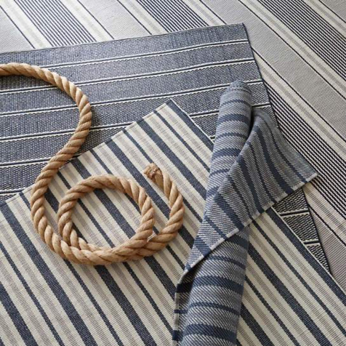 Archer Navy Woven Cotton Rug styled with blue rugs. Styled view. 