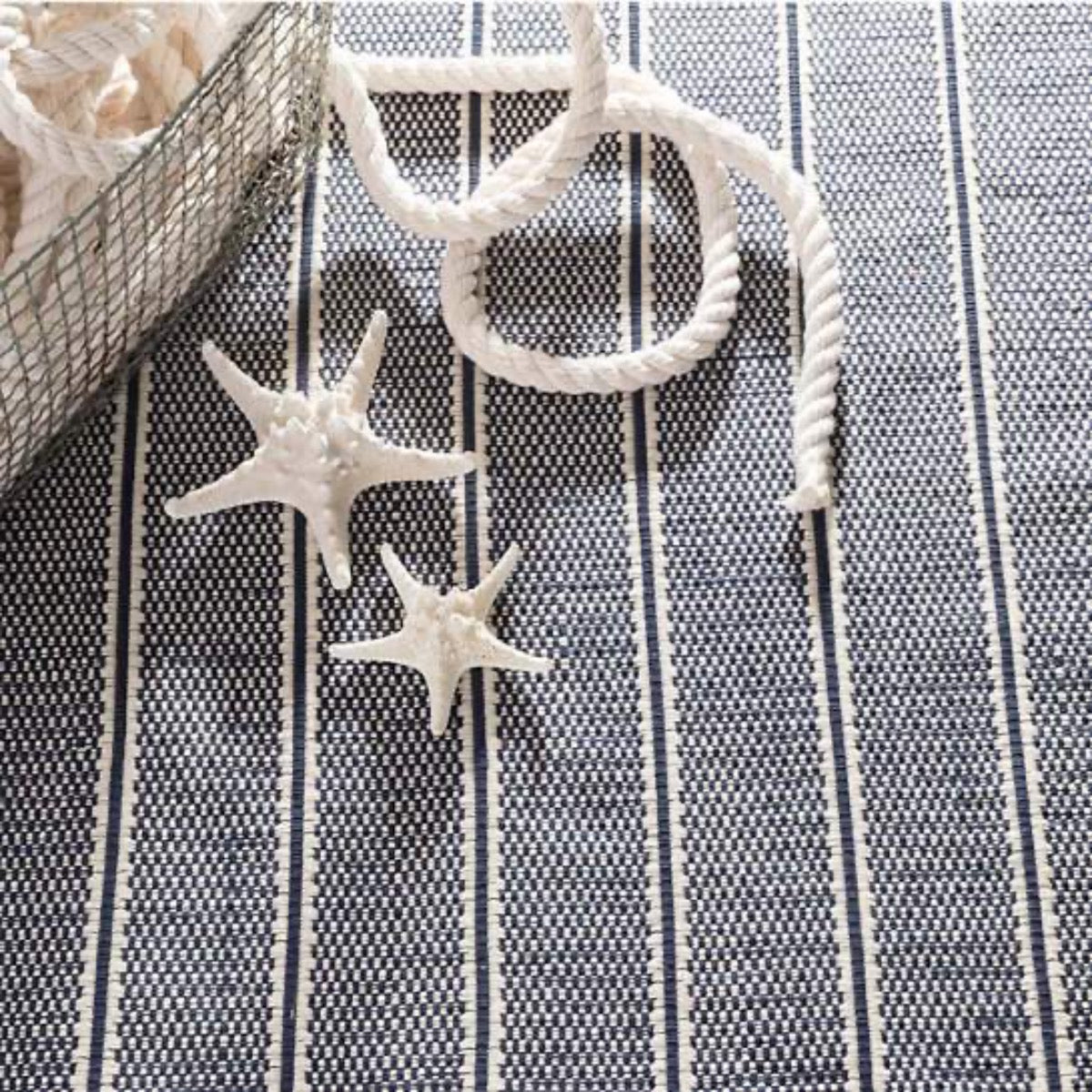 Archer Navy Woven Cotton Rug styled with nautical decor. Styled view. 