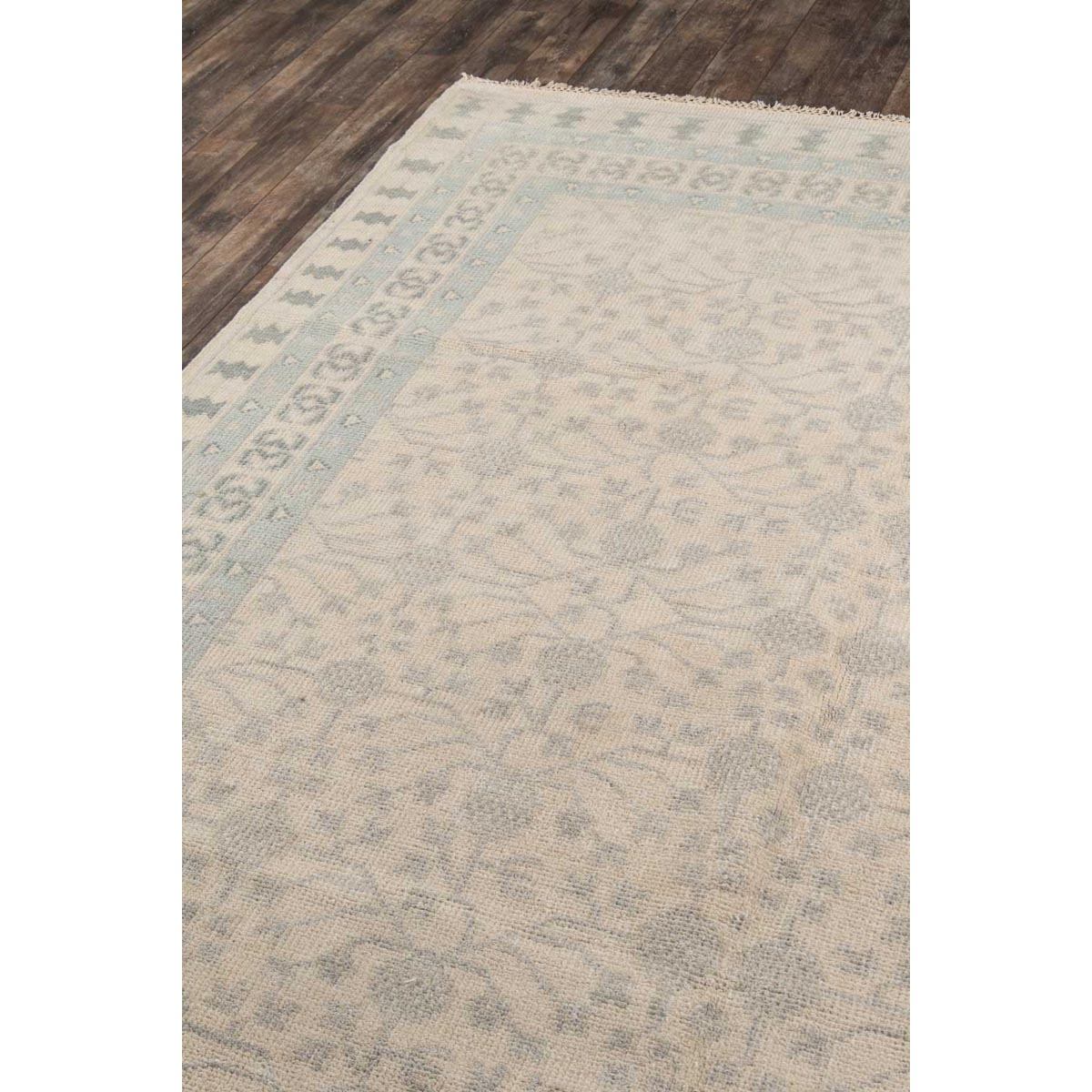 Avery Hand-Knotted Rug over wood floor. Styled view. 
