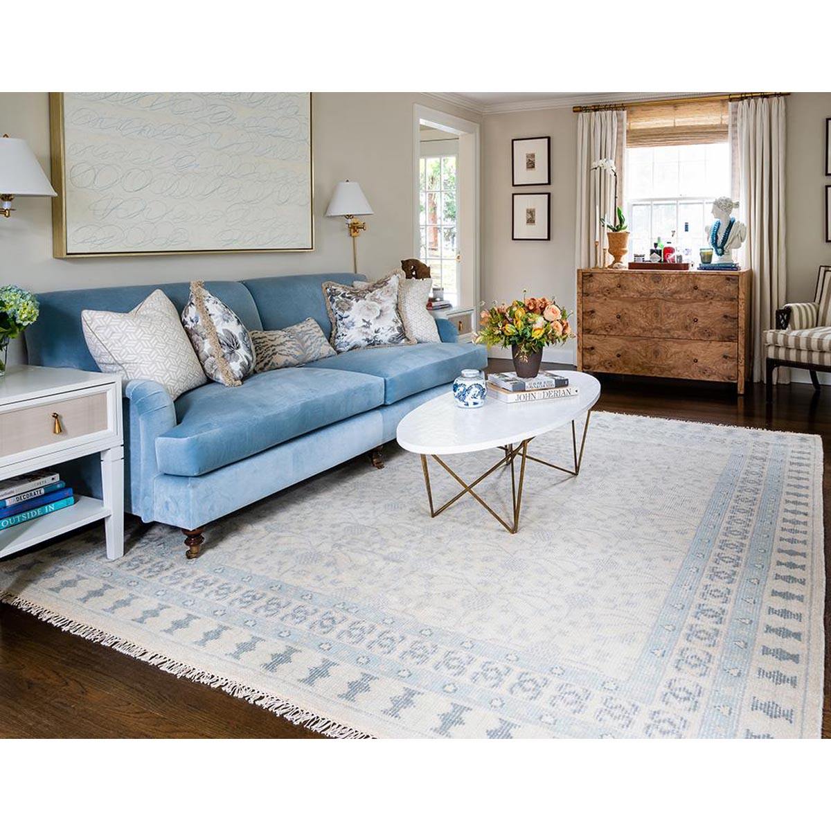Avery Hand-Knotted Rug styled in a living room with blue sofa. Styled view. 