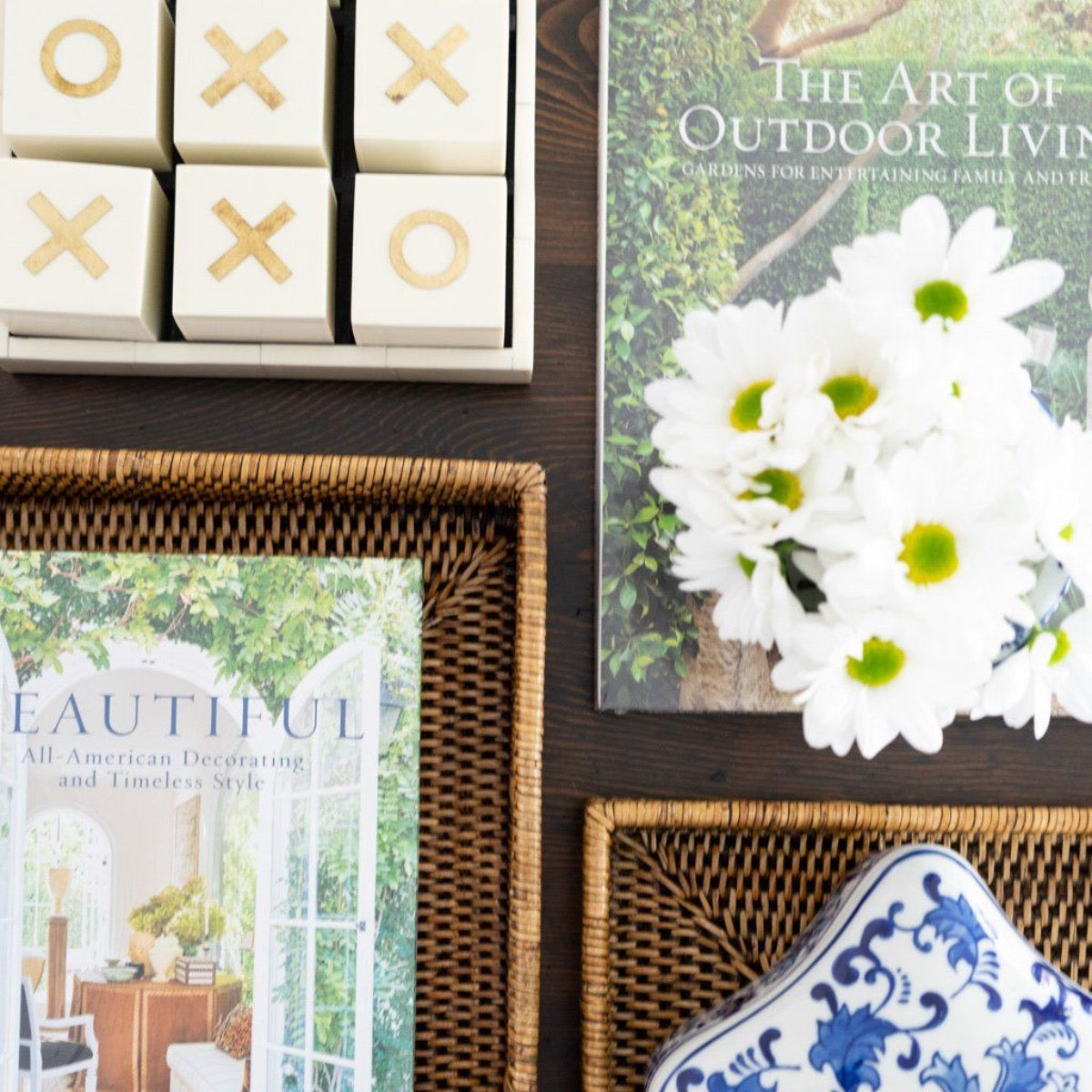 Beautiful - All American Decorating and Timeless Style Books styled with florals and rattan trays. Styled view.