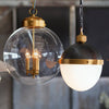 Globe Pendant styled with a black and brass pendant. Styled view.