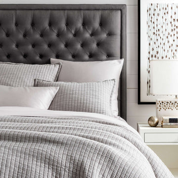 Boyfriend Grey Matelasse Coverlet styled with grey bedding. Styled view. 