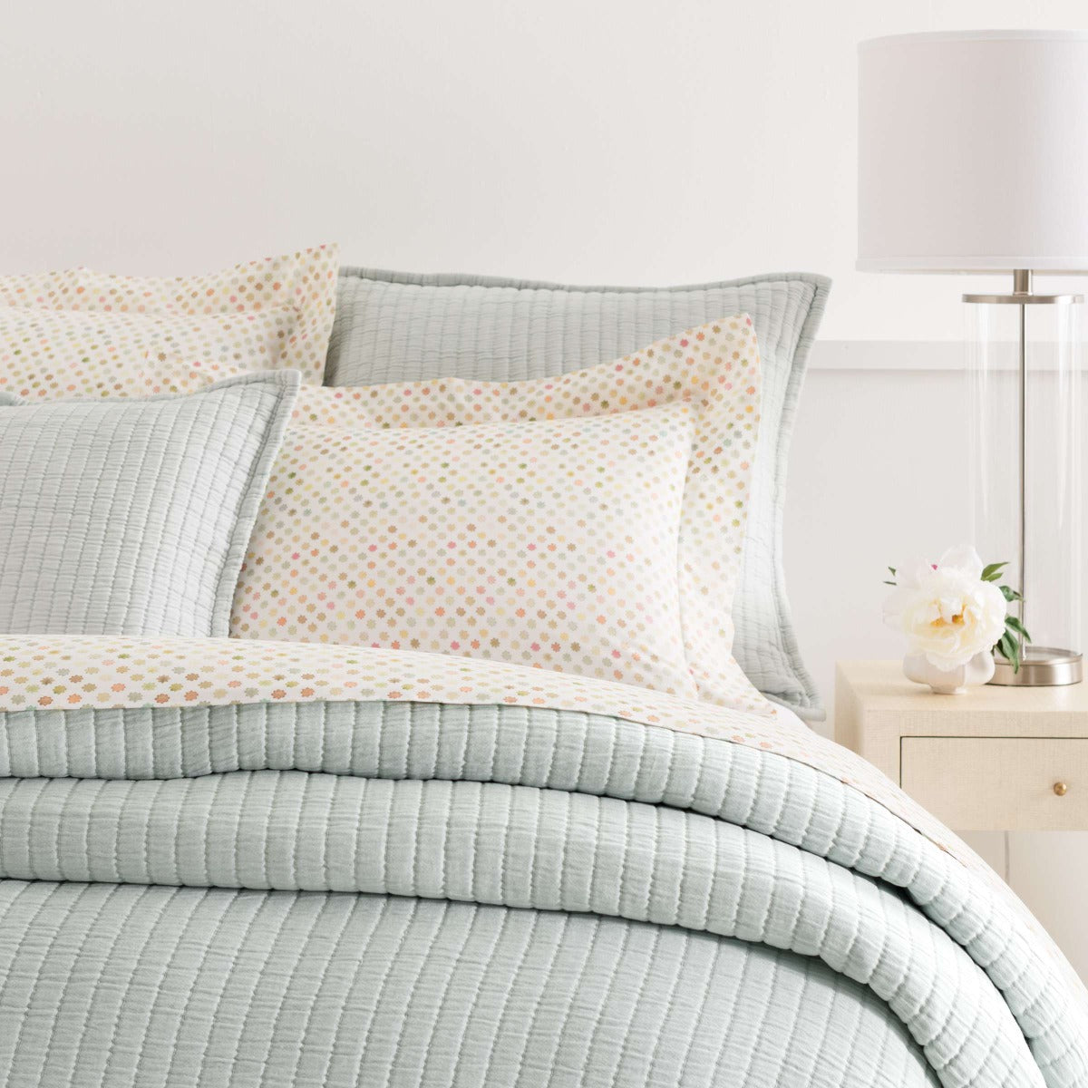 Boyfriend Sky matelasse coverlet styled with polka-dot sheets. Styled view. 
