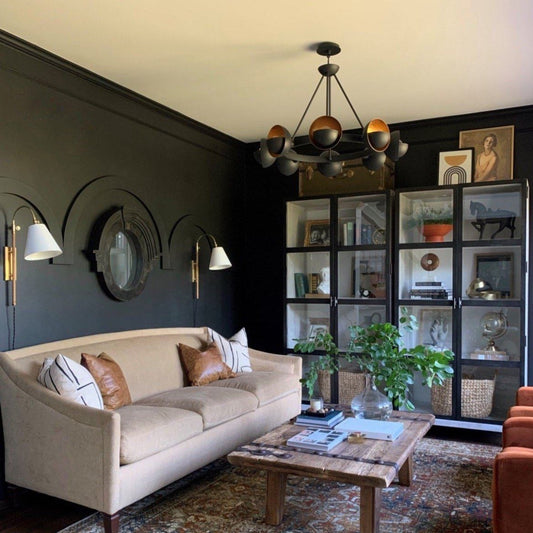 Britton Sconce styled in a green living room. Styled view.