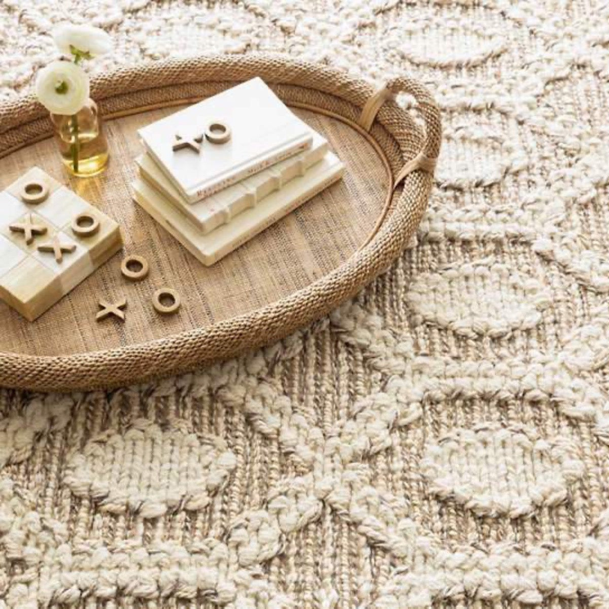 Capri Soumak Woven Jute Rug styled under a woven tray. Styled view. 