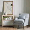 Casey Grasscloth Side Table styled beside a blue accent chair. Styled view.