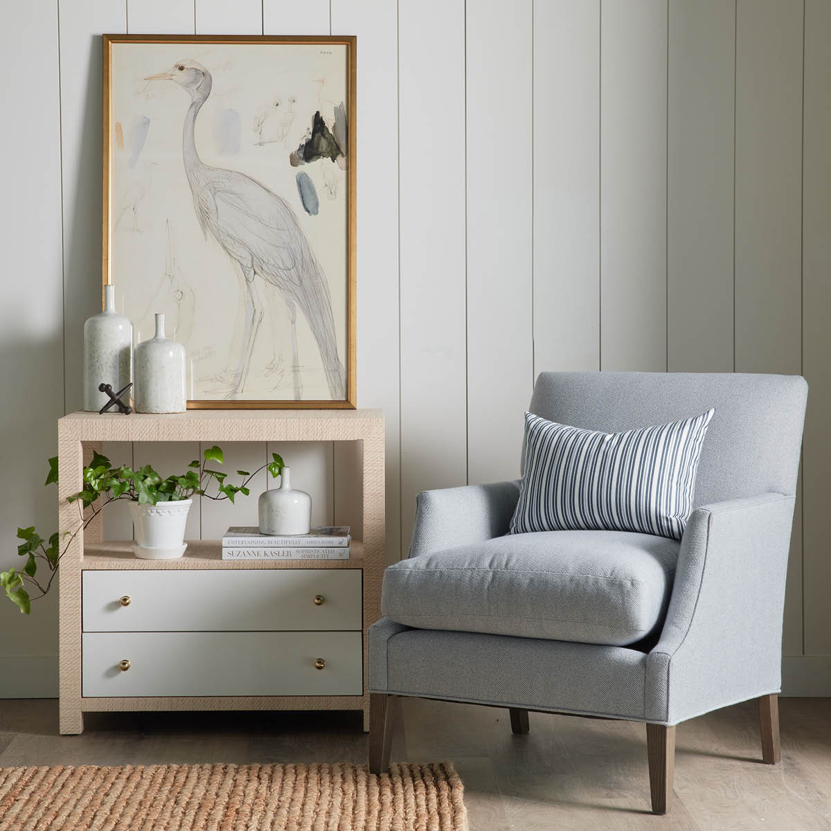 Casey Grasscloth Side Table styled beside a blue accent chair. Styled view.