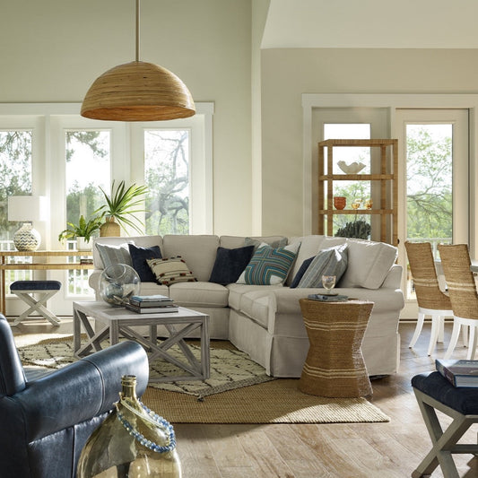 Cecelia Side Table styled beside a grey sectional with rattan and blue accents. Styled view.